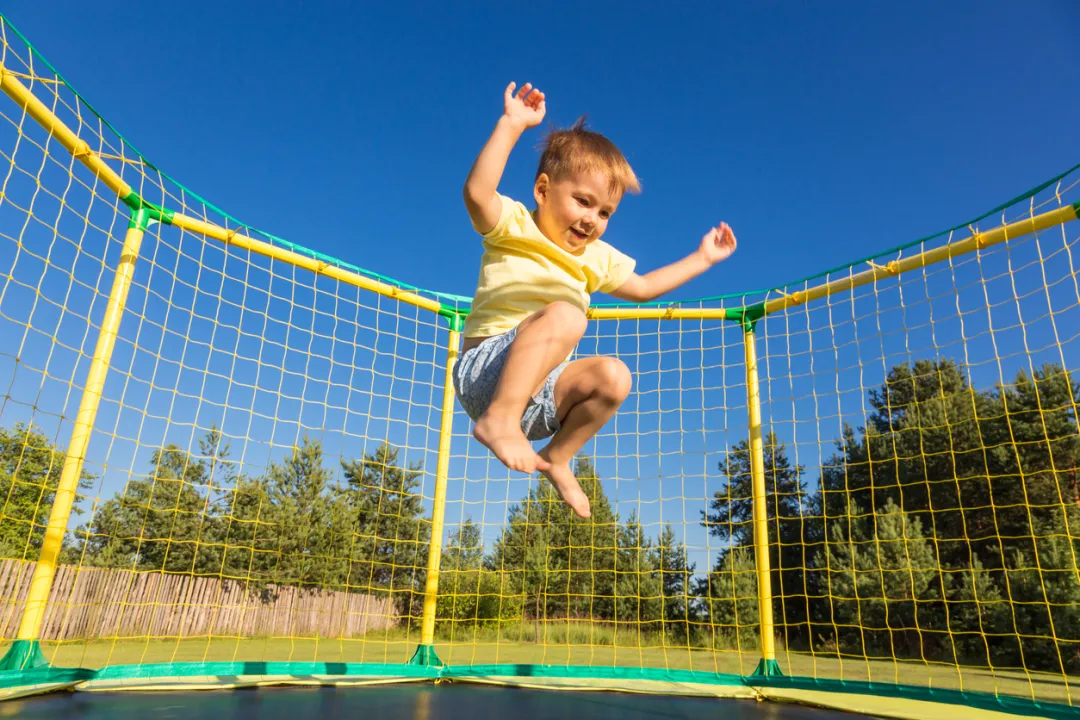 Kind springt glücklich auf dem Trampolin